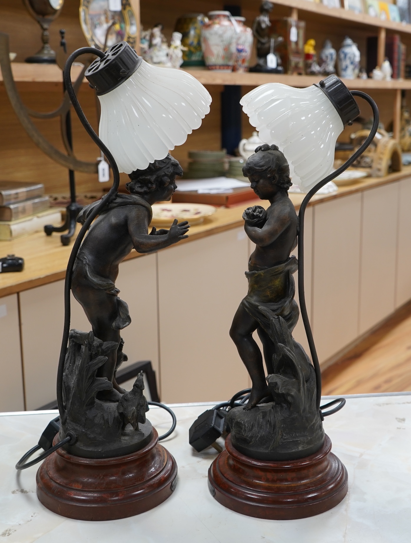 A pair of Art Nouveau style bronzed lady table lamps and glass shades, 48cm including shades and sands